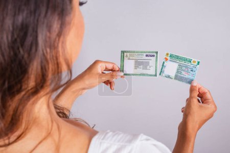 Téléchargez les photos : Mains tenant le permis de conduire et la carte d'identité. Documents brésiliens. - en image libre de droit