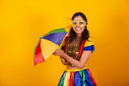 Téléchargez les photos : Belle femme brésilienne en vêtements de carnaval, avec des vêtements frevo, et parapluie coloré et masque. - en image libre de droit