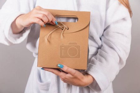 Photo for Closeup photo of cardboard bag with cosmetics, bathrobe background. - Royalty Free Image