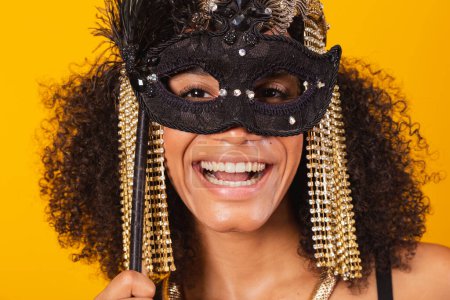 Foto de Hermosa mujer brasileña negra, en ropa de carnaval Cleopatra, sosteniendo máscara de carnaval, tomando retrato de cerca. - Imagen libre de derechos