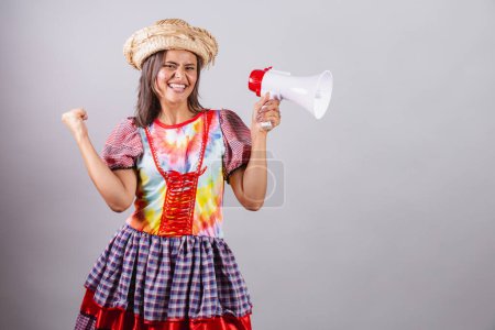 Téléchargez les photos : Femme brésilienne vêtue de vêtements de campagne, fête So Joo, fête Junina. avec mégaphone, promotion, publicité - en image libre de droit