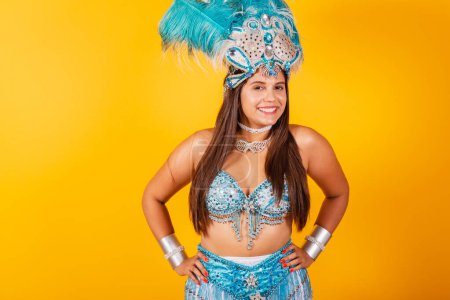 Téléchargez les photos : Belle femme brésilienne en bleu et blanc vêtements de carnaval. avec couronne de plumes, souriant à la caméra. - en image libre de droit