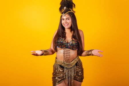 Photo for Beautiful Brazilian woman in golden carnival clothes, with open arms, welcome. - Royalty Free Image