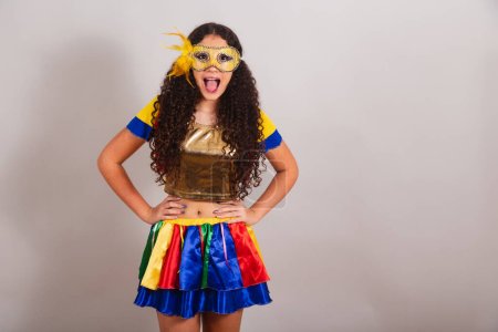 Téléchargez les photos : Jeune adolescente, brésilienne, avec des vêtements frevo, carnaval. Masque, mains sur les hanches. posant pour la photo. - en image libre de droit