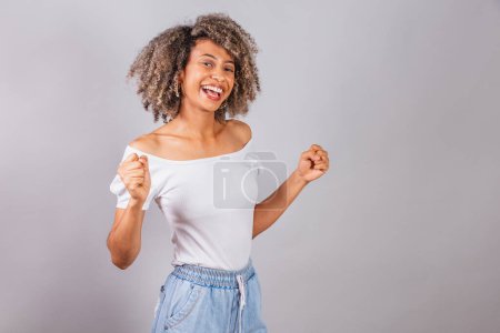 Photo for Beautiful black brazilian woman, in casual clothes, celebrating and partying. - Royalty Free Image