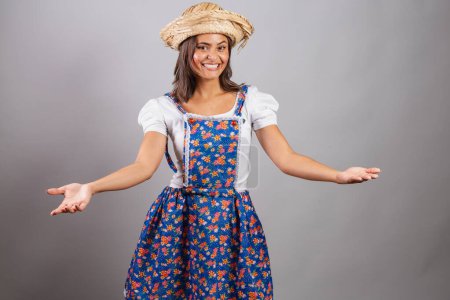 Foto de Mujer brasileña vistiendo ropa de campo, fiesta So Joo, fiesta Junina. Con los brazos abiertos, bienvenidos. - Imagen libre de derechos
