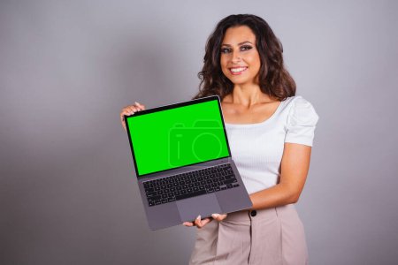 Foto de Mujer brasileña sosteniendo un cuaderno. navegar por la web, sitios web, informatización. Internet.. - Imagen libre de derechos