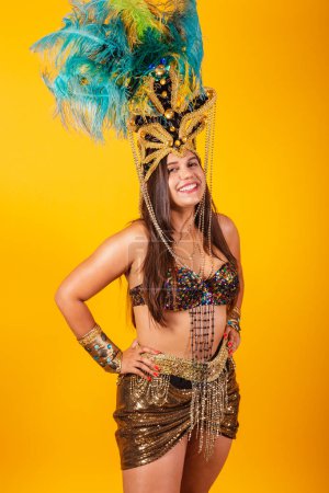 Téléchargez les photos : Belle femme brésilienne en vêtements de carnaval d'or, portant la couronne de plumes de danseur de carnaval. photo verticale. - en image libre de droit