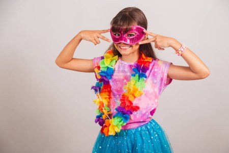 Foto de Hermosa chica brasileña, niña, vestida para el carnaval en Brasil. con máscara de carnaval, bailando. - Imagen libre de derechos