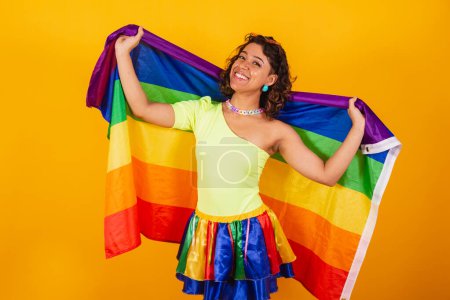 Téléchargez les photos : Belle femme brésilienne afro-américaine, en vêtements de carnaval, tenant le drapeau lgbt. Fierté gay. - en image libre de droit