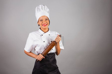 Téléchargez les photos : Chef cuisinier brésilien, originaire du Nord-Est, tenant un rouleau à pâtisserie en bois pour la préparation du pain et des pâtes. - en image libre de droit