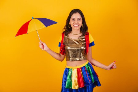 Photo for Beautiful brazilian woman in carnival clothes, with frevo clothes, and colorful umbrella dancing. - Royalty Free Image
