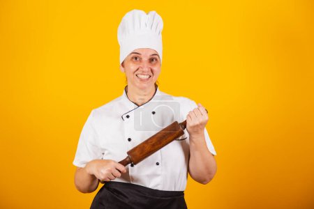 Photo for Adult Brazilian woman, chef, master in gastronomy. Cook. holding wooden rolling pin for preparing pasta and pizza. - Royalty Free Image