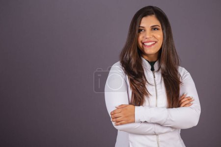 Foto de Foto horizontal. mujer brasileña con abrigo médico, nutricionista. con los brazos cruzados. - Imagen libre de derechos