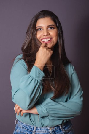 Photo for Vertical photo. Beautiful Brazilian woman, with casual clothes, Jeans and green shirt. Smiling pose. - Royalty Free Image