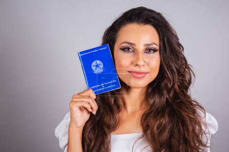 Photo for Brazilian woman, brown hair, holding work card and social security. Formal work. - Royalty Free Image