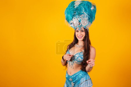 Téléchargez les photos : Belle femme brésilienne avec des vêtements de reine de l'école de samba, carnaval. Couronne de plumes, pointant vers la caméra. - en image libre de droit