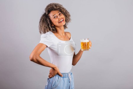 Photo for Beautiful black brazilian woman in casual clothes holding glass of beer. - Royalty Free Image