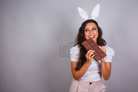 Photo for Brazilian woman, with bunny ears and chocolate bar. - Royalty Free Image