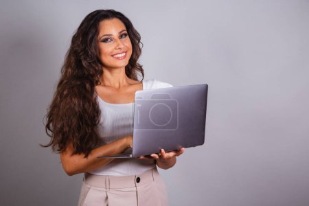 brazilian woman holding notebook. browsing the web, websites, computerization. Internet.