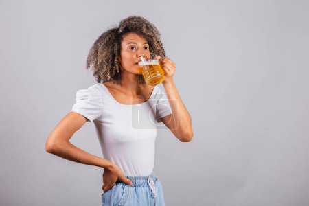 Photo for Beautiful black brazilian woman in casual clothes holding glass of beer. - Royalty Free Image