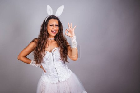 Téléchargez les photos : Femme brésilienne, avec des vêtements de lapin. doigts ok signe. - en image libre de droit