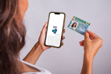 Photo for Hands holding driver's license and smartphone. Apps. - Royalty Free Image