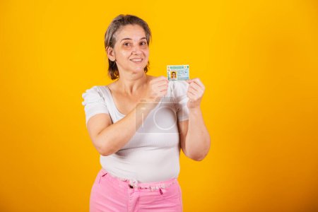 Photo for Adult Brazilian woman holding driver's license. - Royalty Free Image