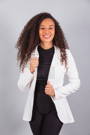 Photo for Vertical photo, beautiful black Brazilian woman, businesswoman, wearing white suit, facing camera. - Royalty Free Image