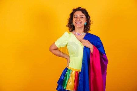 Téléchargez les photos : Belle femme brésilienne afro-américaine en vêtements de carnaval tenant drapeau lgbt bisexuel. Fierté bisexuelle. - en image libre de droit