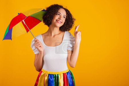 Photo for Beautiful Brazilian woman, dressed in carnival clothes, colorful skirt and white shirt. cheering, sign of luck. wishing. - Royalty Free Image