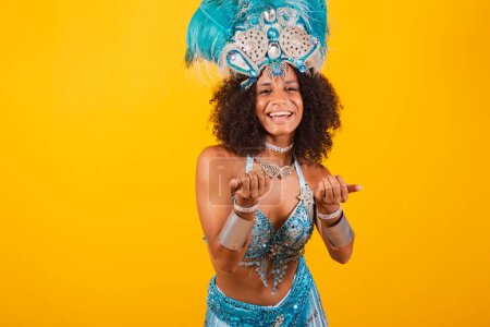 Téléchargez les photos : Femme noire reine de l'école de samba brésilienne, avec des vêtements de carnaval bleu et couronne de plumes. invitant les mains. - en image libre de droit