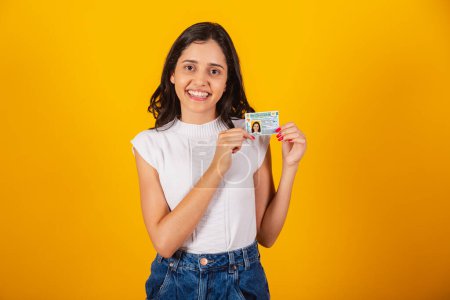 Photo for Beautiful brazilian woman holding driver's license document. - Royalty Free Image