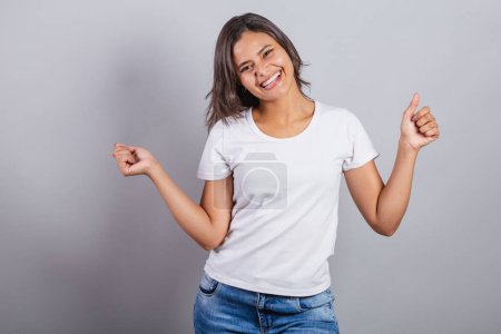 Photo for Beautiful brazilian woman. denim and white. smiling, dancing. optimistic, very happy. - Royalty Free Image