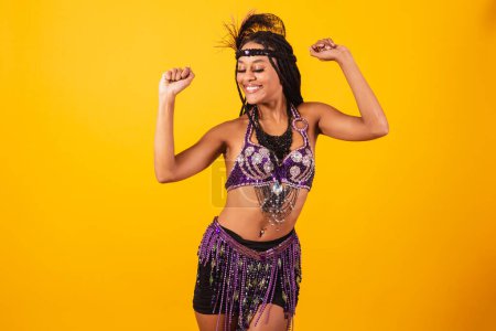 Foto de Hermosa mujer brasileña negra, en ropa de carnaval púrpura, bailando. - Imagen libre de derechos