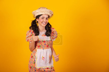 Téléchargez les photos : Belle femme brésilienne, avec des vêtements de fête de juin, genre, signe positif. - en image libre de droit