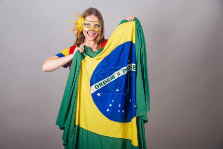 Foto de Mujer rubia brasileña, vestida con ropa frevo, máscara de carnaval, bandera de Brasil. - Imagen libre de derechos