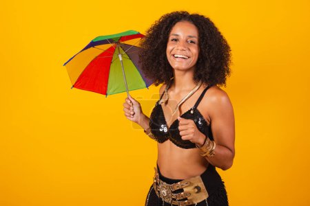Téléchargez les photos : Belle femme brésilienne noire, vêtue de carnaval Cleopatra, tenant un parapluie coloré. - en image libre de droit