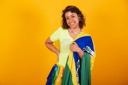 Foto de Hermosa mujer brasileña afroamericana, en ropas de carnaval, sosteniendo la bandera de Brasil. - Imagen libre de derechos