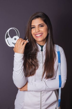 Téléchargez les photos : Photo horizontale. femme brésilienne avec manteau médical, nutritionniste. adipomètre et ruban à mesurer. minceur. - en image libre de droit