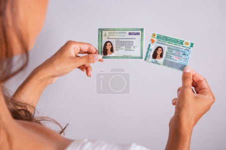 Photo for Hands holding driver's license and identity card. Brazilian documents. - Royalty Free Image