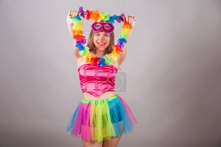 Téléchargez les photos : Femme blonde brésilienne vêtue de vêtements de carnaval rose. avec collier de fleurs. - en image libre de droit