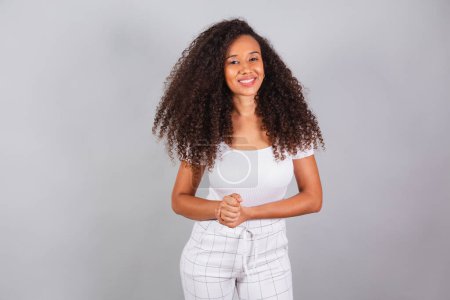 Photo for Horizontal photo, beautiful black Brazilian woman, dressed in white, casual clothes, smiling. - Royalty Free Image