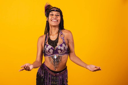 Foto de Hermosa mujer brasileña negra, en ropa de carnaval púrpura, con los brazos abiertos, bienvenida. - Imagen libre de derechos
