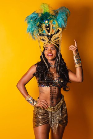 Téléchargez les photos : Vertical, half body shot, Femme brésilienne noire en tenue de carnaval posant pour une photo. - en image libre de droit