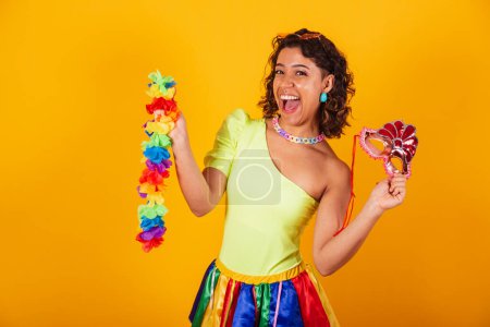 Photo for Beautiful afro american brazilian girl, in carnival clothes, wearing flower necklace and and carnival mask. - Royalty Free Image