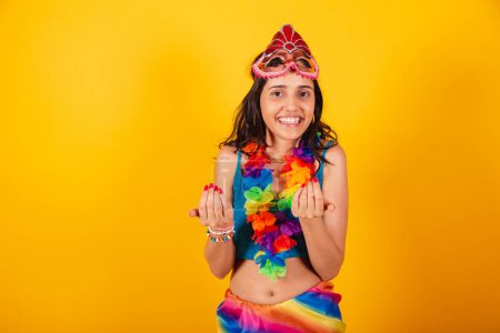 Téléchargez les photos : Belle femme brésilienne en vêtements de carnaval, portant un masque de carnaval et un collier de fleurs, invitant avec les mains. - en image libre de droit