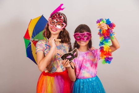 Foto de Dos niños brasileños, niñas, vestidas con traje de carnaval, sosteniendo accesorios de carnaval. - Imagen libre de derechos