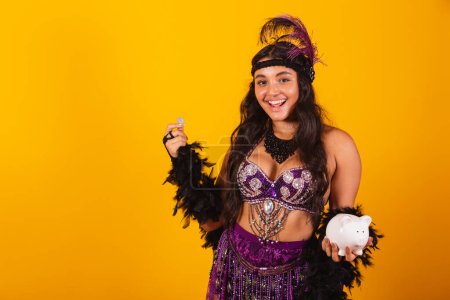 Téléchargez les photos : Femme brésilienne, portant des vêtements de carnaval, tenant tirelire et pièce de monnaie. - en image libre de droit