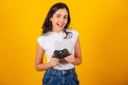 Foto de Hermosa mujer brasileña sosteniendo controlador de videojuegos. mostrando a la cámara. - Imagen libre de derechos